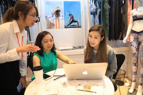 Một nhà thiết kế thời trang giới thiệu sản phẩm đến đối tác người Việt.